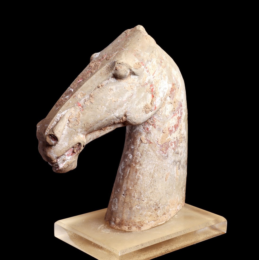 Han Terracotta Horse Head: China. Han Dynasty, ca. 206 BCE - 220 CE. Large molded terracotta horse head with flared nostrils, originally fitted on a large wooden horse sculpture, depicted with a long angular snout, lips parted 