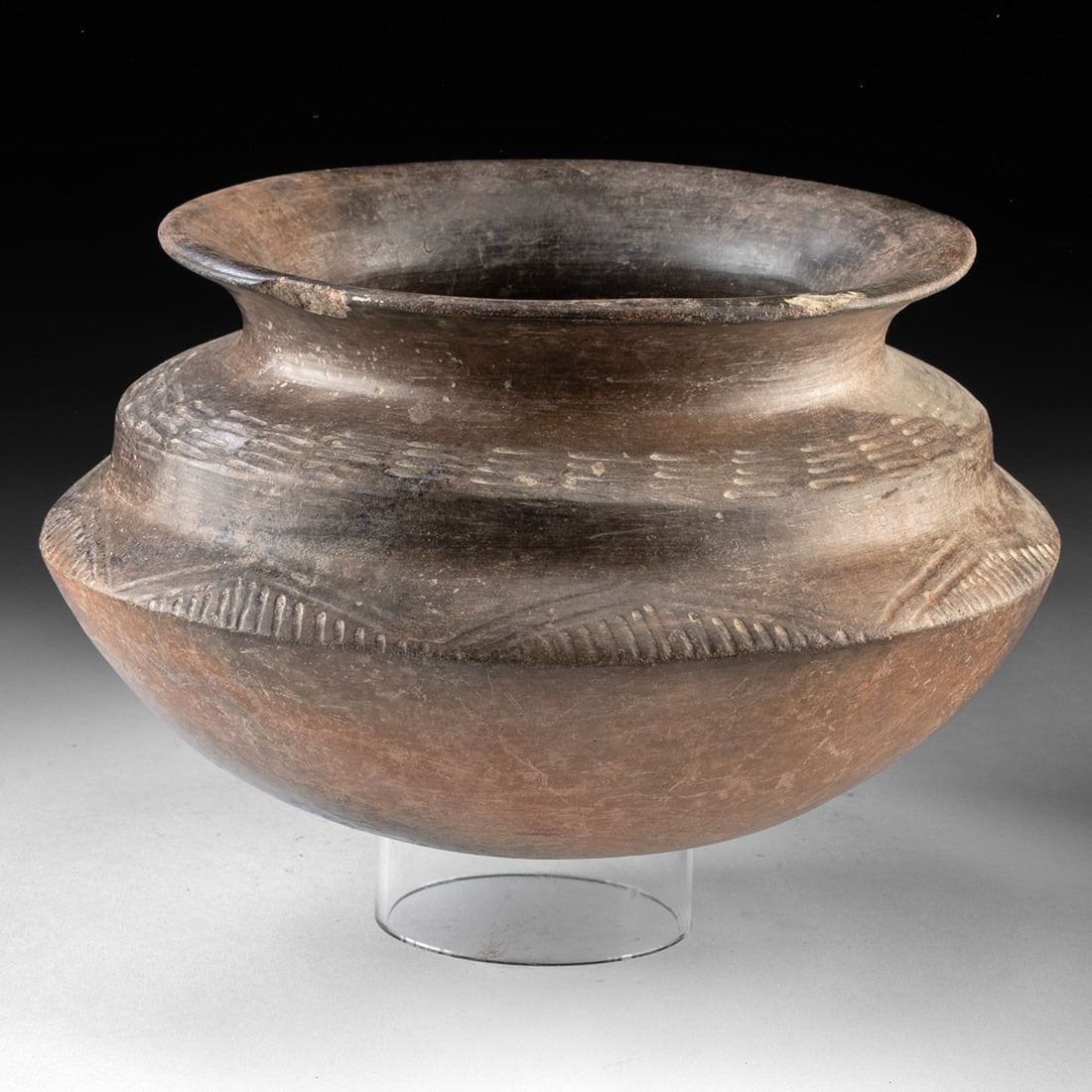 Chupicuaro Blackware Tiered Jar w/ Incised Bands: Pre-Columbian, Mexico, Chupicuaro culture, ca. 400 BCE to 200 CE. A broad-shouldered Chupicuaro jar of tiered biconical profile, its burnished clay surface ranging from warm terracotta at the base to 