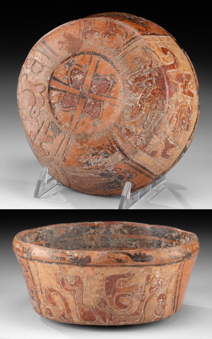 Maya Polychrome Bowl - Monkey & Reptilian Figures: Pre-Columbian, Maya, Honduras or El Salvador, ca. 600 to 900 CE. A petite hand-built pottery bowl slipped in warm orange, with two painted dark bands encircling the interior. The underside bears a qua
