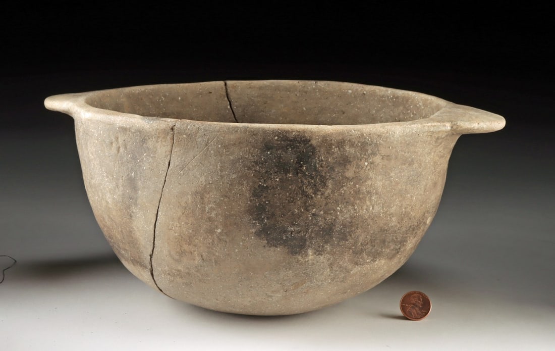 Mississippian Pottery Bowl with Handles: United States, Native American, Mississippi Valley, ca. 800 to 1400 CE. A hemispherical bowl with two opposed, flat lug handles set flush to a slightly everted rim, its gently mottled, smoke-darkened 