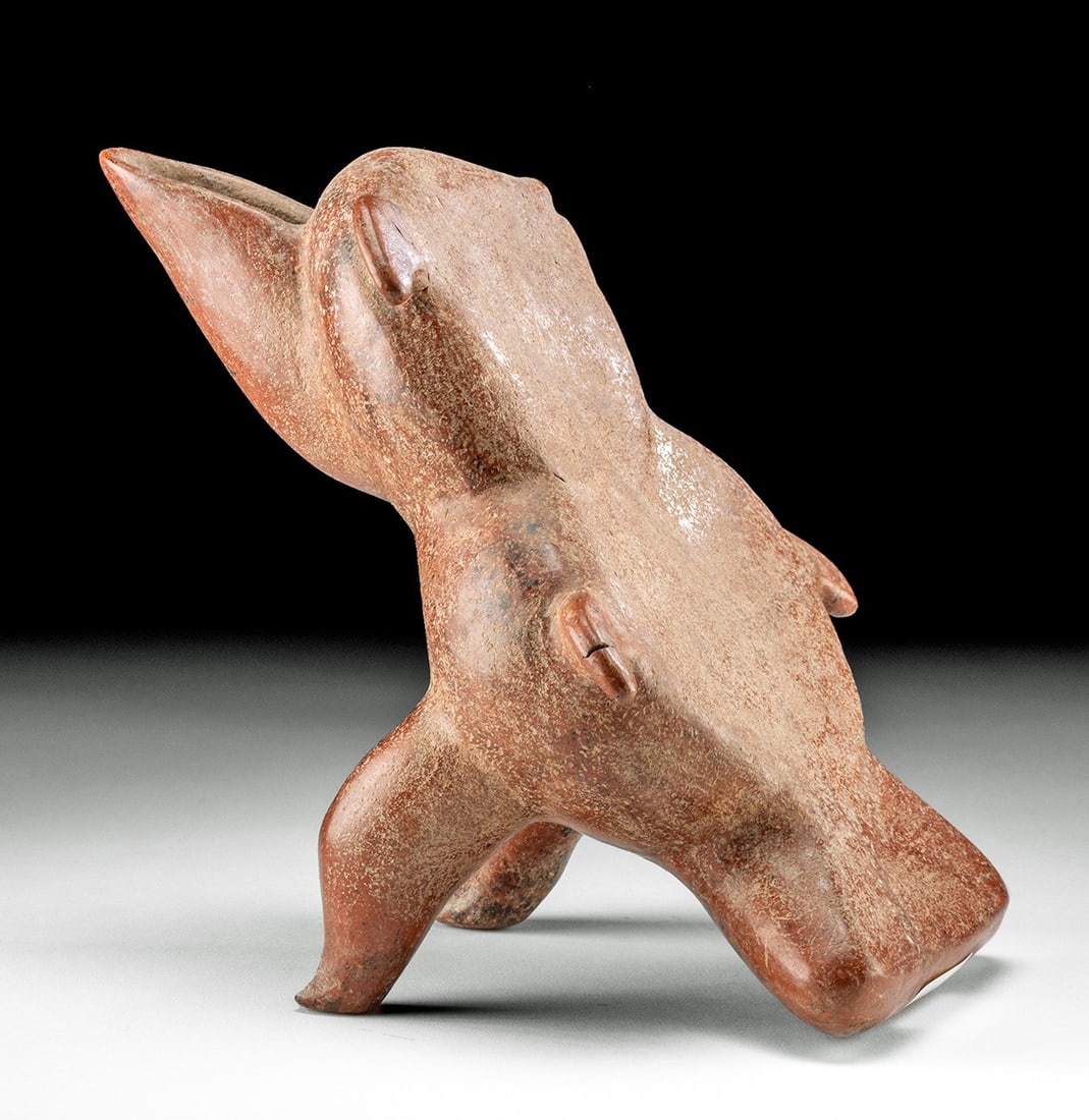 Colima Reclinatorio - Abstract Zoomorphic Form: Pre-Columbian, West Mexico, Colima, ca. 300 BCE to 300 CE. An impressive hand-made pottery reclinatorio depicting an abstract creature, perhaps a dolphin, a fish, or a bird. The front of the vessel is
