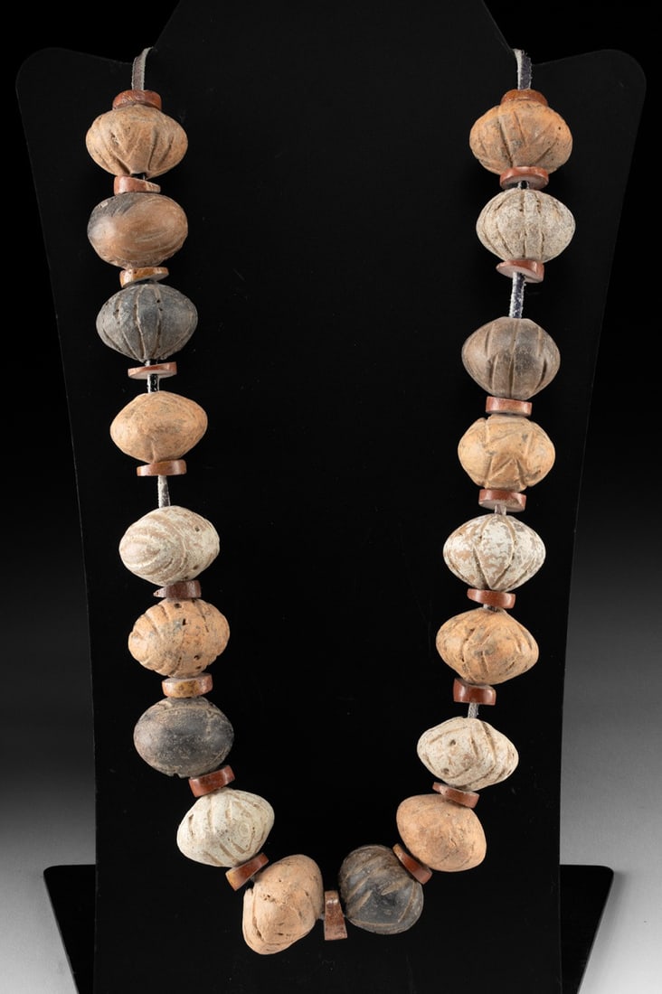 African Pottery Whorl & Red Stone Disc Bead Strand: West Africa, ca. 19th to mid-20th century CE. A strand of large pottery spheres interspersed with small red stone disc spacers. The hand-shaped ceramic whorls show varied earthy tones and incised surf