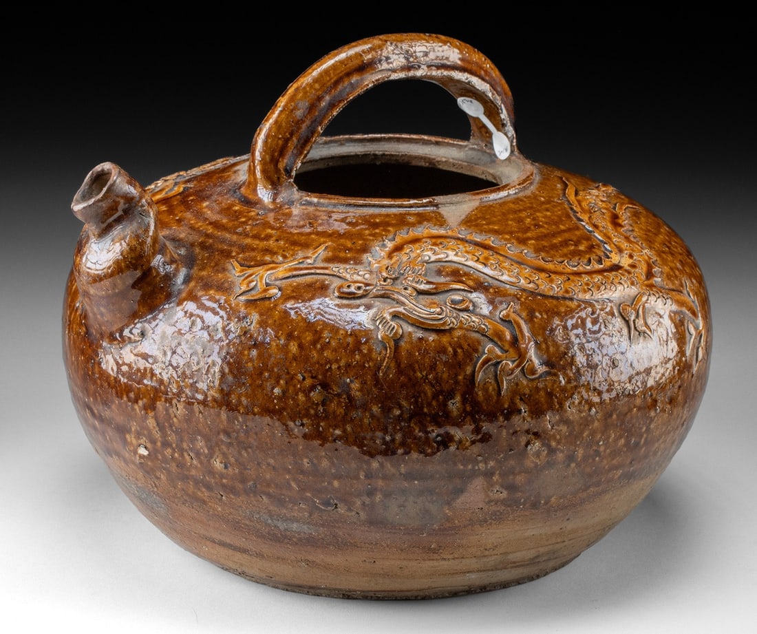 Chinese Ming Dynasty Brown Glazed Dragon Pot: East Asia, China, Ming to Qing Dynasty, ca. 16th to 18th century CE. A large stoneware teapot vessel featuring a spout, handle, and a raised dragon motif around the shoulder. The piece reflects a low-