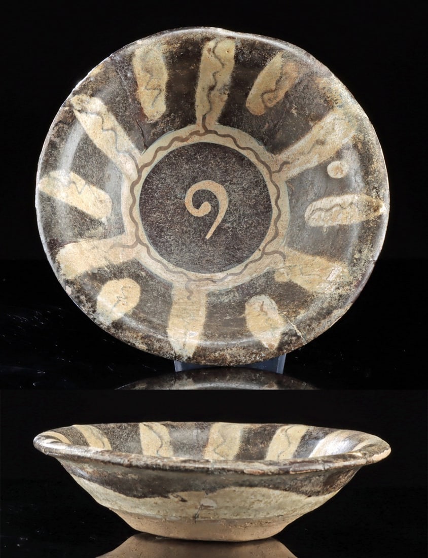 Petite Nishapur Islamic Pottery Bowl, Black & White: Central Asia or Eastern Iran, Samanid Empire, likely Nishapur, ca. 10th to 12th century CE. A petite earthenware dish decorated in black slip with bold radiating motifs and a central spiral design. Su