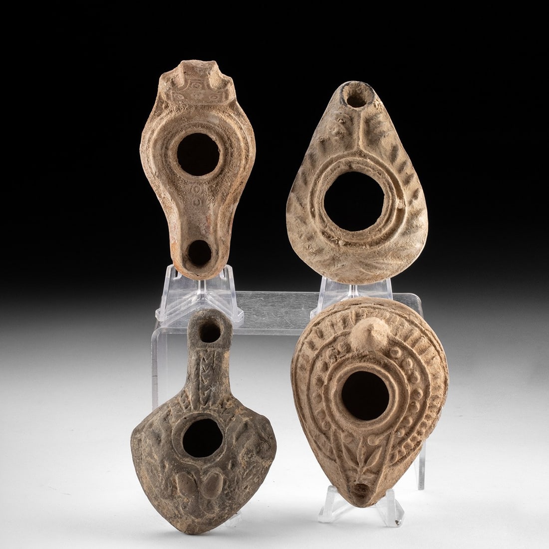 Four Holy Land Pottery Oil Lamps: Holy Land, Levant, Israel, Lebanon, Jordan or Syria, Roman period, ca. 1st to 3rd centuries CE. Ensemble of four mold-made terracotta oil lamps, each tear or pear shaped with a central filling orifice