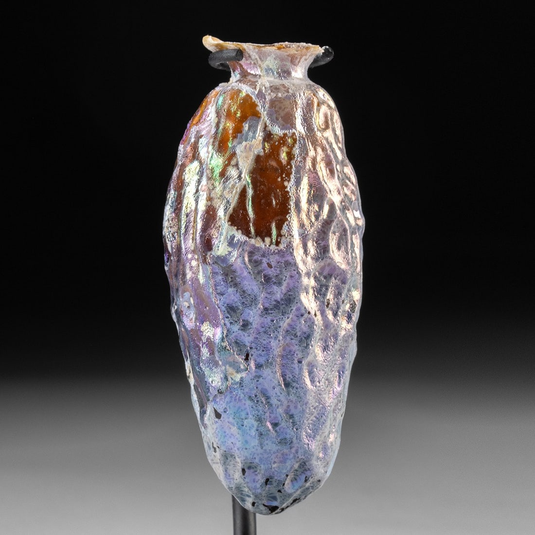 Roman Sidonian Glass Date Flask: Roman Empire, Lebanon, Sidonian, ca. mid 1st to early 2nd century CE. A fine mold blown flask resembling a date fruit in gorgeous golden amber glass with amazing iridescence - its generally oblong for