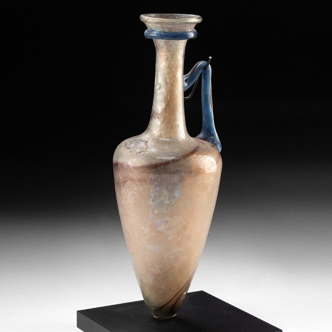 Roman Glass Amphoriskos w/ Blue Handle: Roman, Imperial period, ca. 1st to 3rd century CE. A free-blown glass amphoriskos of elegant elongated form, its tapering ovoid body rising to a slender cylindrical neck and outfolded disc rim. A sing