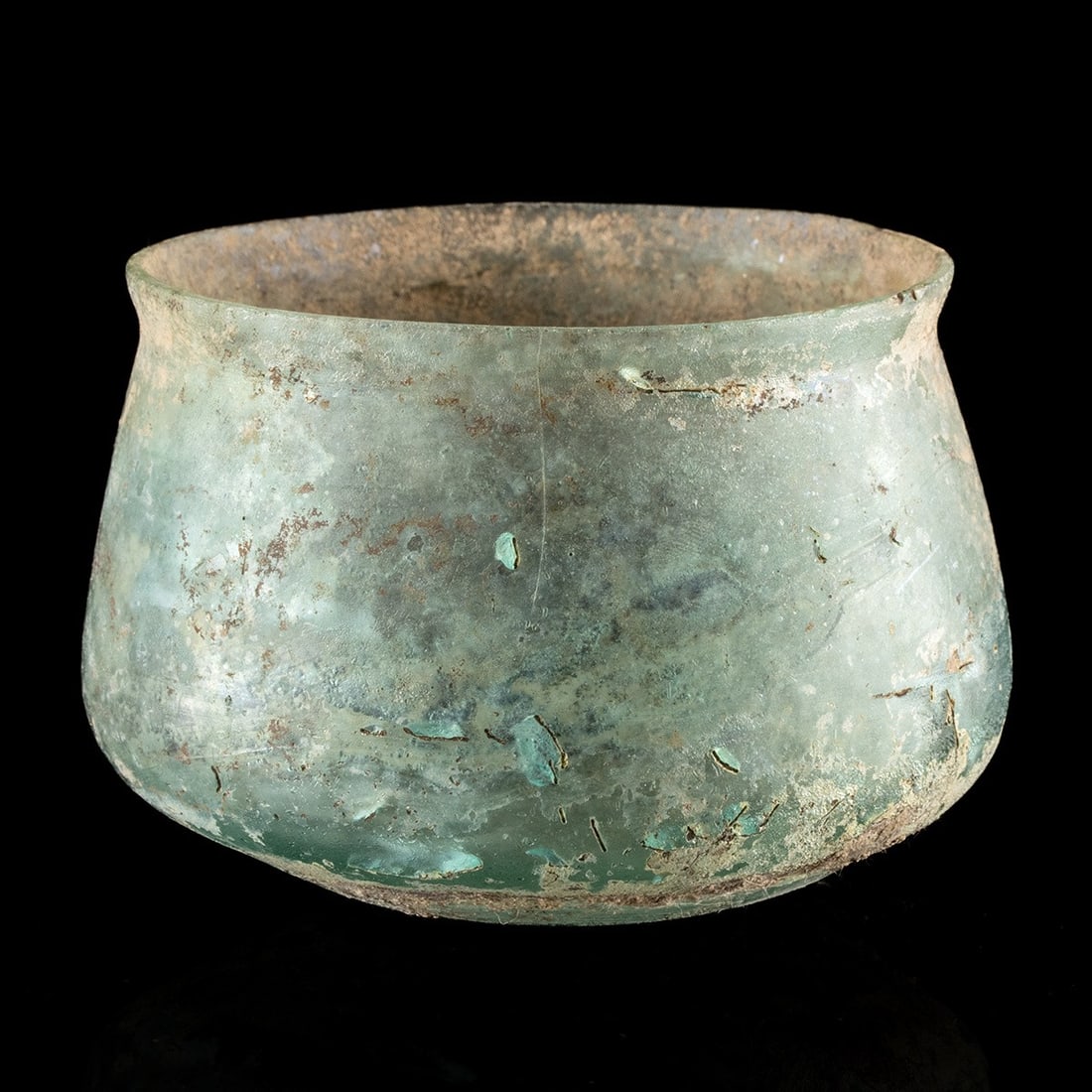 Roman Glass Vessel: Roman Period, ca. 1st to 4th century CE. A carinated glass vessel with a robust, rounded lower half with a flattened bottom. It features a wide opening, enclosed by a thin, uniform rim. Its surface is