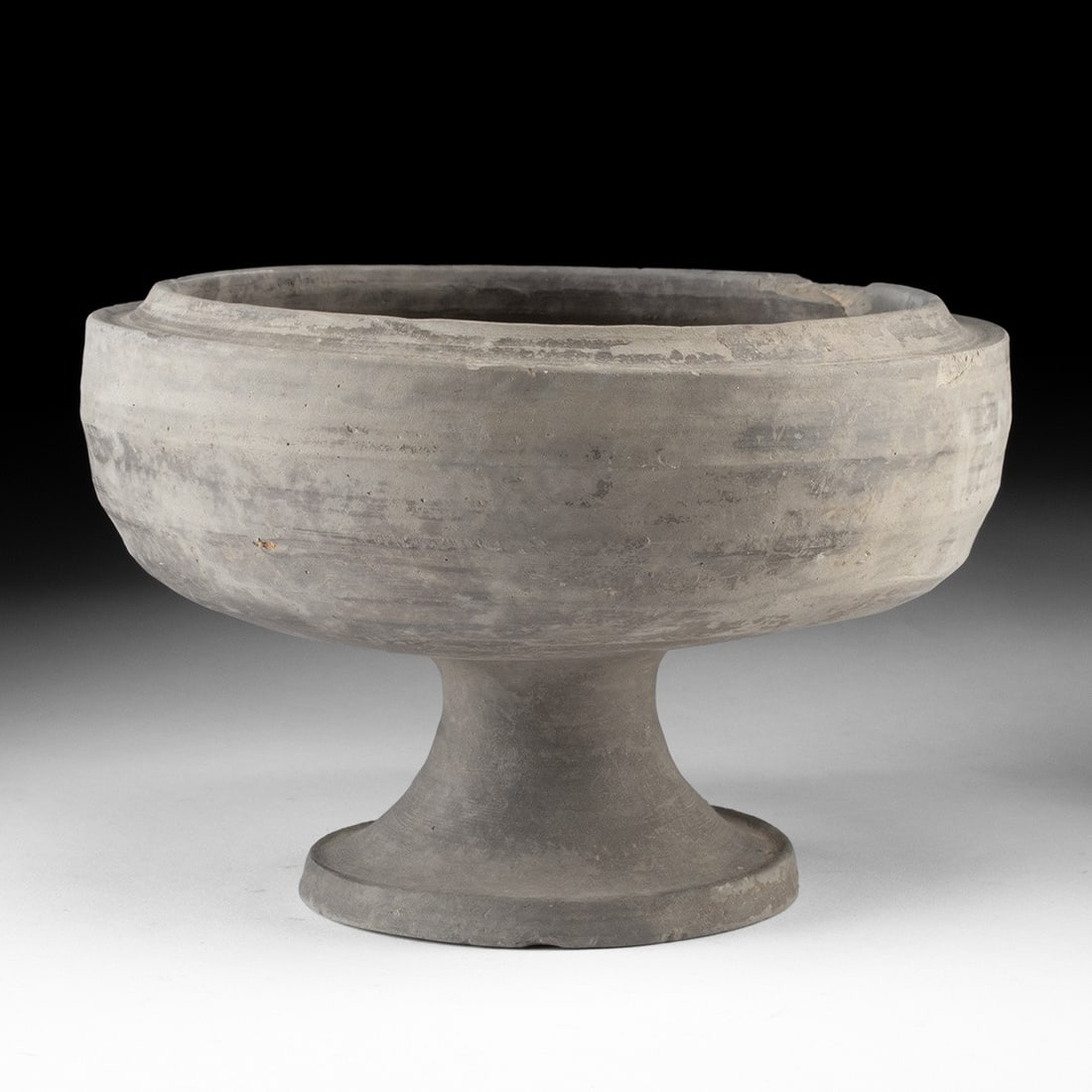 Zhou Dynasty Unglazed Pottery Dou Footed Vessel: East Asia, China, Eastern Zhou to early Han Dynasty, ca. 11th century BCE to 2nd century BCE. A wheel-thrown grey pottery pedestal bowl (dou) of characteristic form, the wide shallow bowl raised on a 