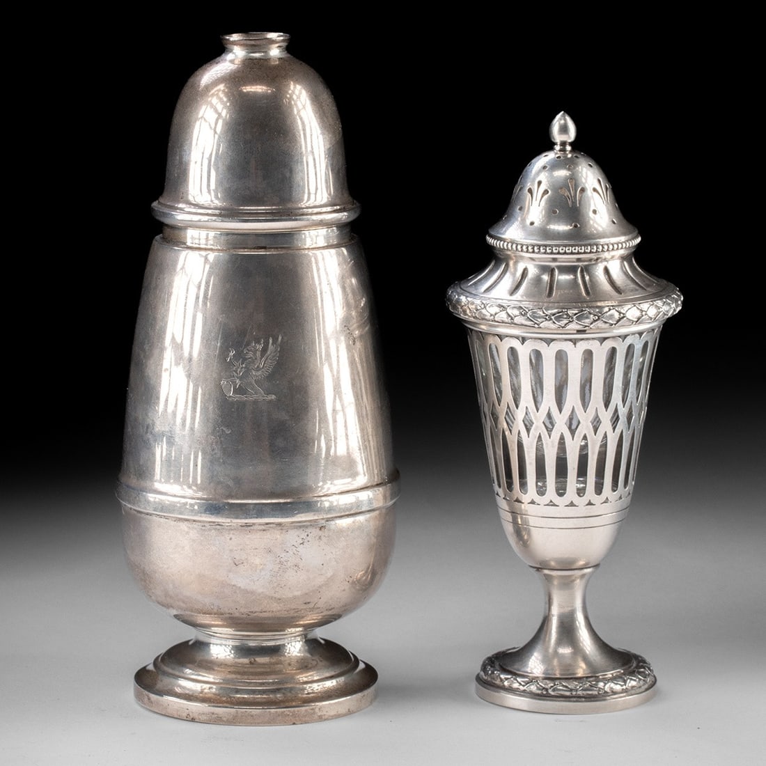 Two Sterling Silver Muffineers - Birmingham: England and the United States, Birmingham for the larger, and unmarked for the smaller, ca. 1875 CE. Pair of sugar casters, called muffineers, made over 100 years ago. Larger with family crest of a gr