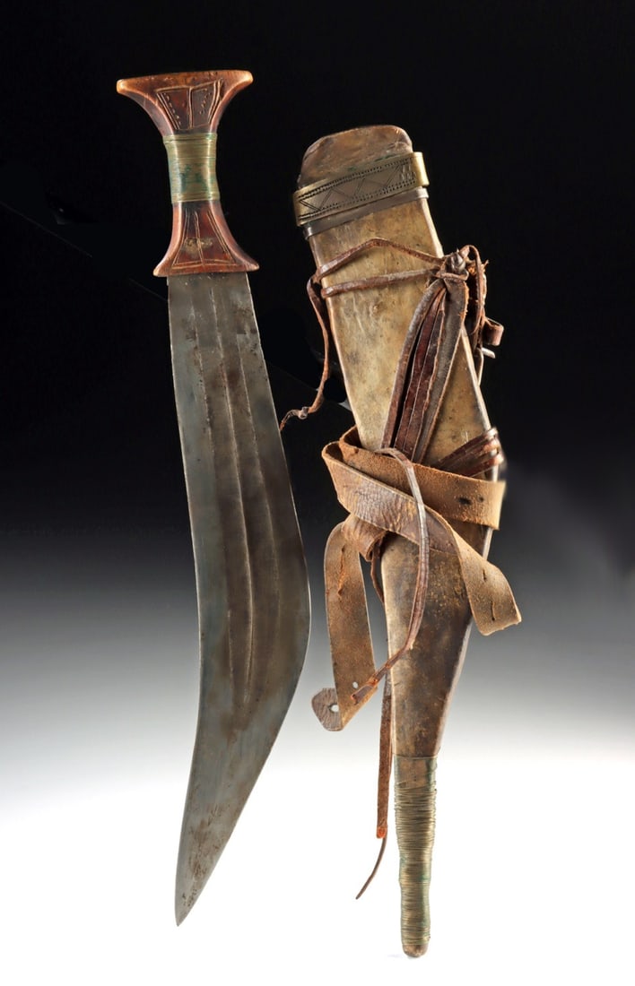 19th C. Gile Knife & Sheath, Ethiopian Nomadic Weapon: East Africa, Ethiopia / Djibouti, Afar Region, ca. 19th to early 20th century CE. A fine example of an Afar (Danakil) gile (jile) knife, featuring a broad, curved double-edged blade of forged iron. Th