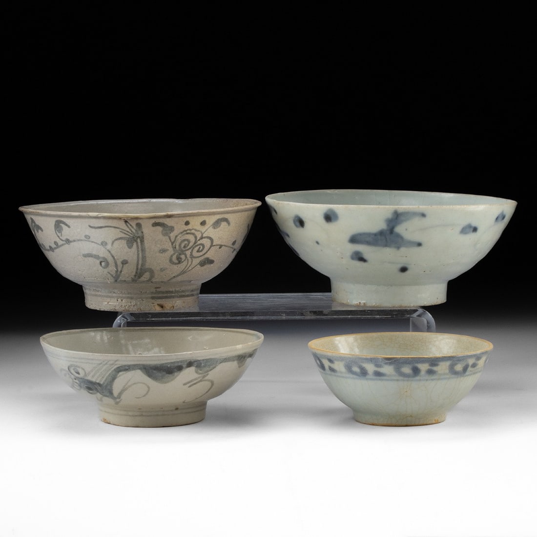 Four Decorated Blue on White Ming Dynasty Rice Bowls: Nice lot of 4 early porcelain bowls found along Chinese or Anamese trading routes of the 15th to early 16tth centuries. Traditional rice bowls, each decorated in a blue on white, one example gray on t