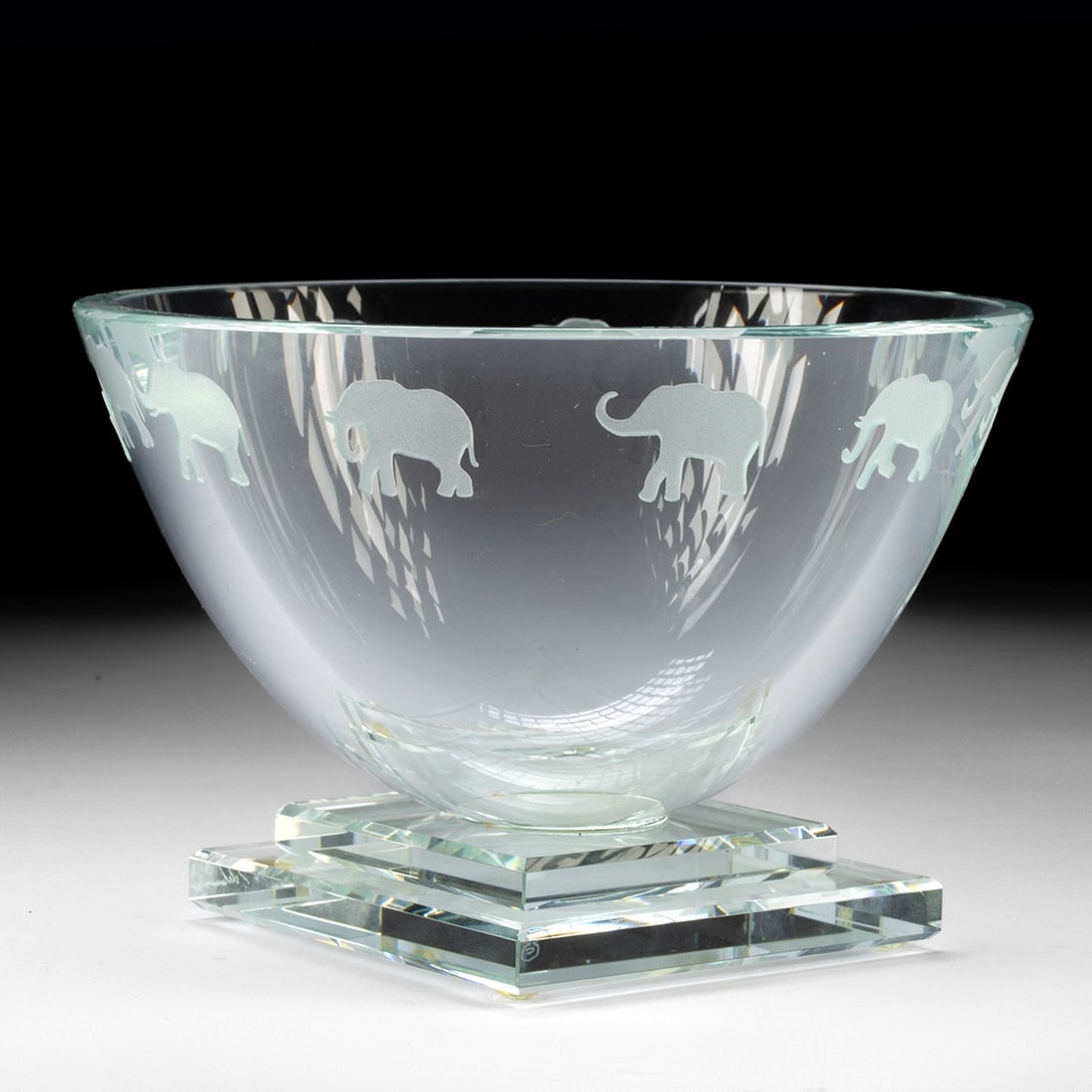 Etched Glass Elephant Bowl by Stephen Schlanser: Stephen Schlanser (American, b. 1949) "Elephant Bowl," ca. 1996 CE. This large kiln-fired glass bowl showcases a charming marching elephant design. Resting on a square pedestal base, with the artist's