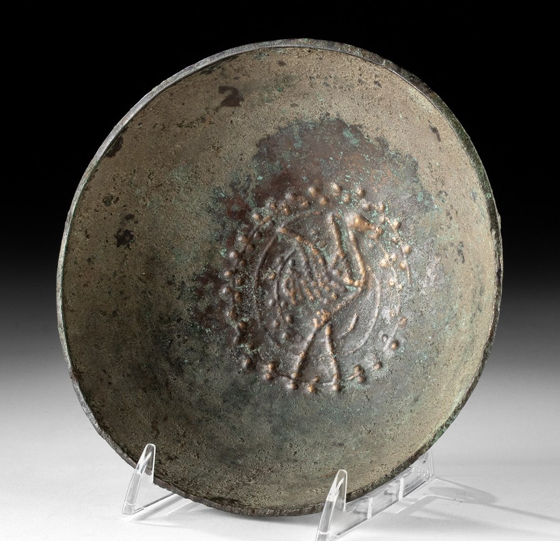 Ancient Sasanian Empire Bronze Bowl Repousse Stork / Dotted Border: A bronze bowl featuring a repousse motif of a long-legged stork at the center tondo, encircled by a dotted border. The bird is rendered in low relief with its wings outspread, an elegant emblem of fer
