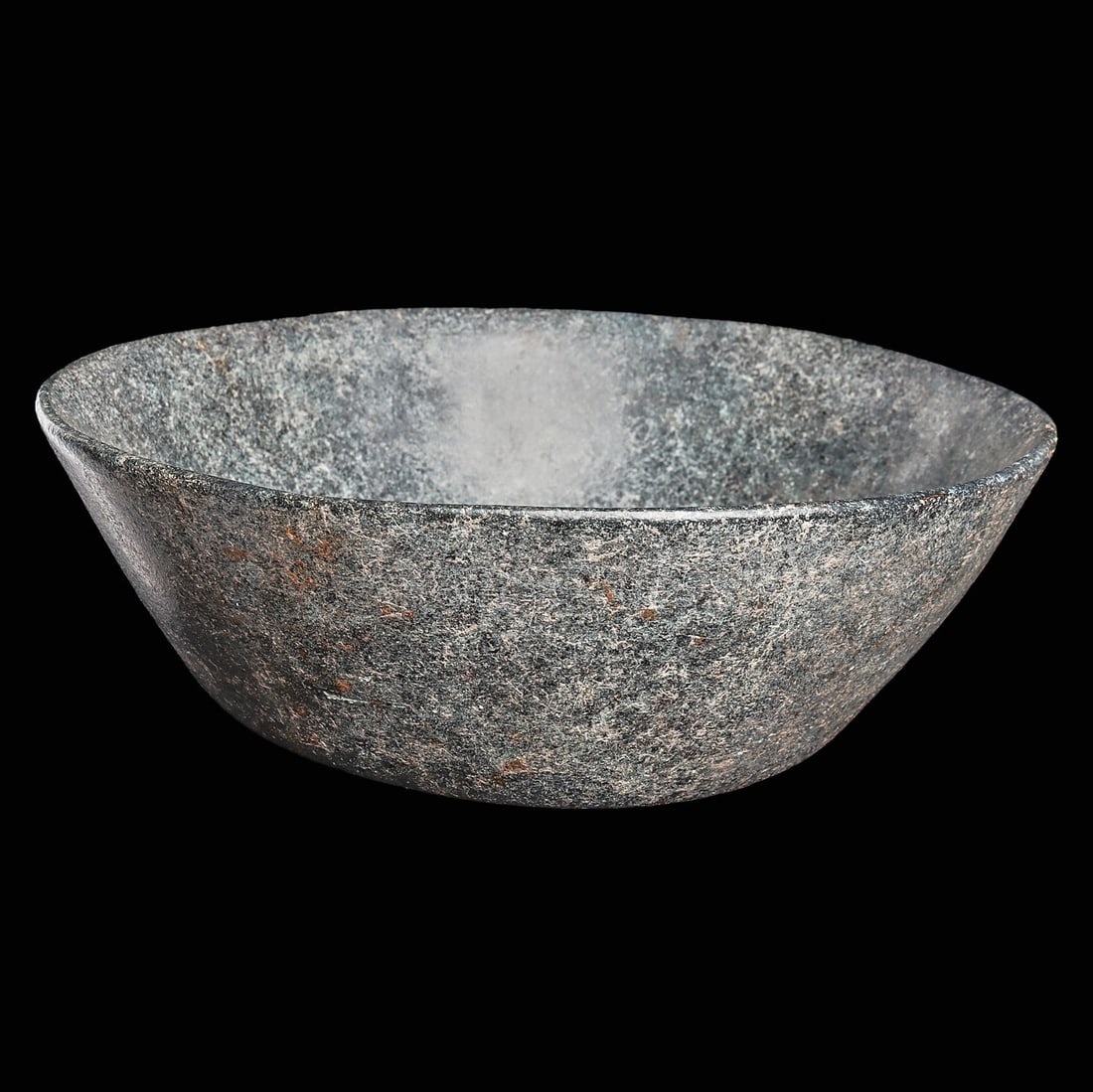 Xochipala Stone Bowl: Olmec regions, ca. 1000 - 800 BCE. Carved bluish-green and black speckled stone bowl, having thin walls, a slightly flared rim, and a flat bottom.3.5”H x 9.375”D (8.9 x 23.8cm). Provenance