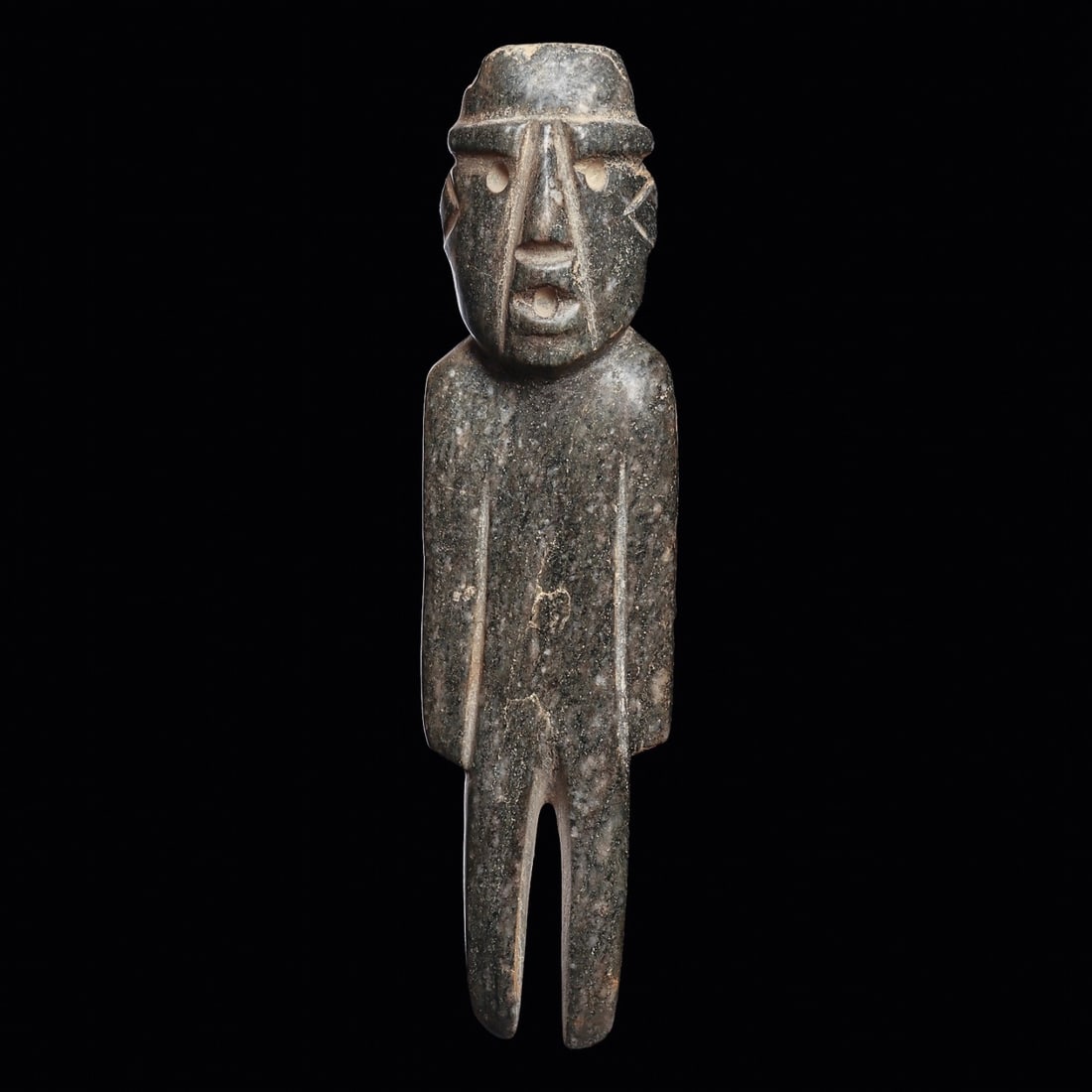 Guerrero Gray-Green Serpentine Standing Figure: Guerrero, ca. 600 - 400 BCE. Tall carved deep bluish-green serpentine standing figure holding his arms to his sides. Ovoid head having expressive facial features, drilled eyes and mouth with thick car