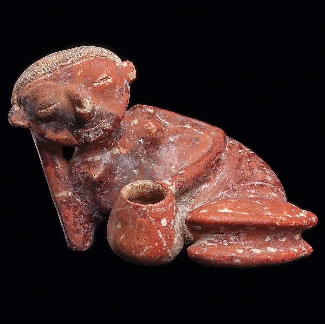 Chinesco Reclining Female with Bowl: Lagunillas Type B, Nayarit, ca. 100 BCE - 250 CE. Red-brown slip glazed pottery reclining female figure holding a bowl with her left hand, legs folded, incised striated and cross hatched hairdo. The r