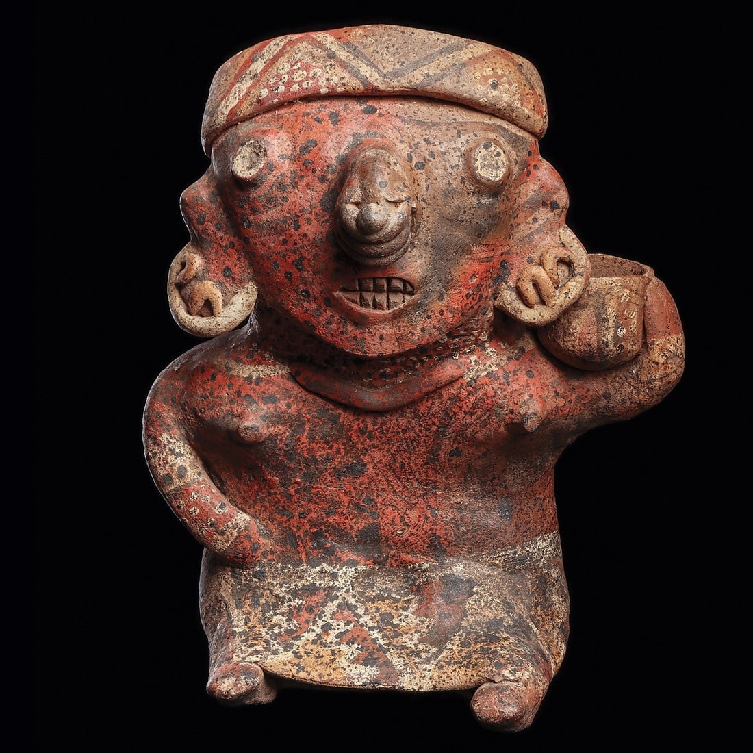 Ixtlan del Rio Seated Female Holding Bowl: Nayarit, ca. 100 BCE - 250 CE. Orangeware pottery seated female figure holding a bowl on her left shoulder, wearing an ankle length skirt, fancy ear ornaments, nose ring, wide decorated head band and 