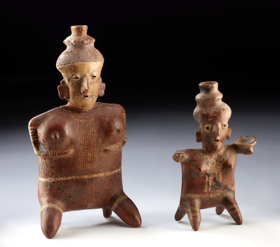 Two Jalisco Polychrome Semi-Nude Female Figures: Pre-Columbian, West Mexico, Nayarit, Ixtlan Del Rio type., ca. 200 BCE - 300 CE. Pair of hand-built pottery pieces, each decorated in polychrome and both of similar form. Each is a female sitting upon