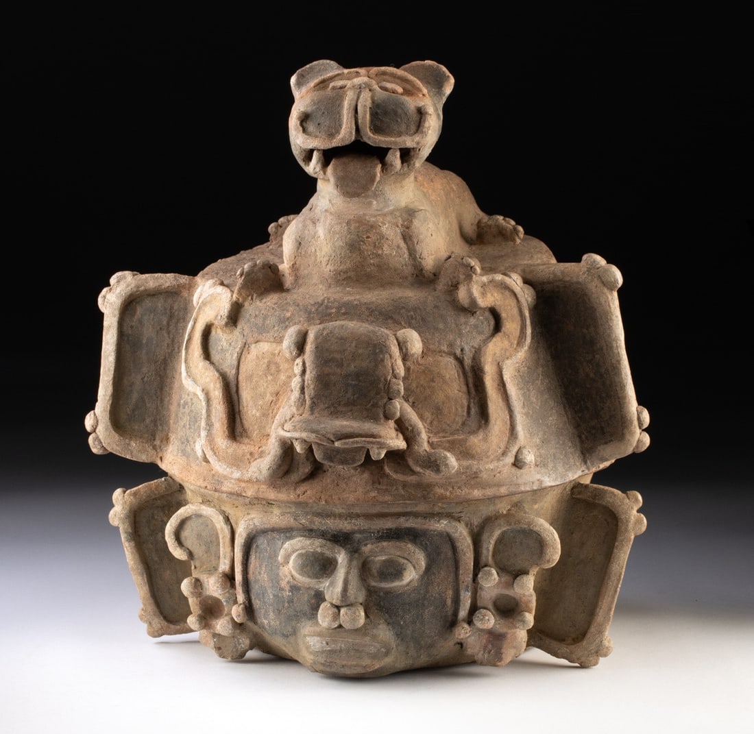 Maya Pottery Lidded Urn with Jaguar Lid: Pre-Columbian, Meso-America, Mexico or Guatemala, Maya., ca. 550 - 900 CE. Crowned by a crouching jaguar with a lolling tongue, this imposing terracotta lidded urn bristles with sculptural energy, its