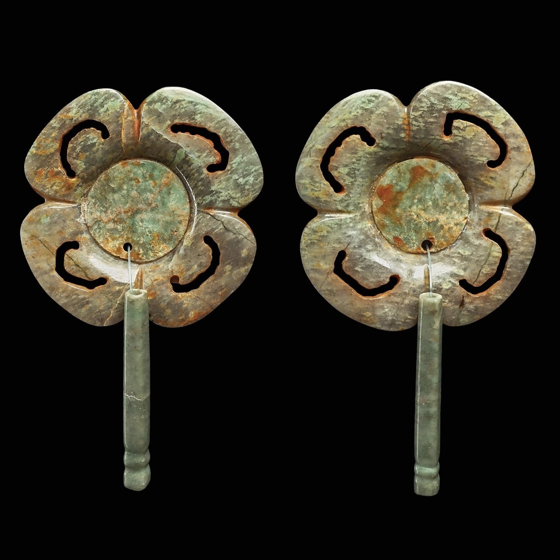 Maya Matching Pair of Jade Floral Ear Flares: Maya regions, ca. 500 - 800 CE. Fine carved matching pair of four petal floral ear ornaments, having a separately carved disc center and a squared tubular dangler. Wide carved integral attachment tube