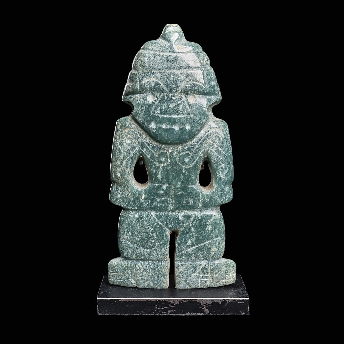 Costa Rican Jade Dancer Deity Pendant: Costa Rica, ca. 500 - 1000 CE. Carved blue-green jade anthropomorphic pendant, depicting a dancer figure, holding both hands on his stomach, wide headband with a center point. Carved and drilled facia