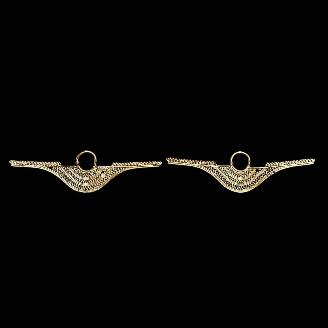 Sinu Gold Filigree Ear Ornaments (2): Sinu, Colombia, ca. 800 - 1450 CE. Fine cast gold ear ornaments of crescent form with long wings, having three bands of openwork diamond net decoration, long wing bars decorated with a long zigzag ele