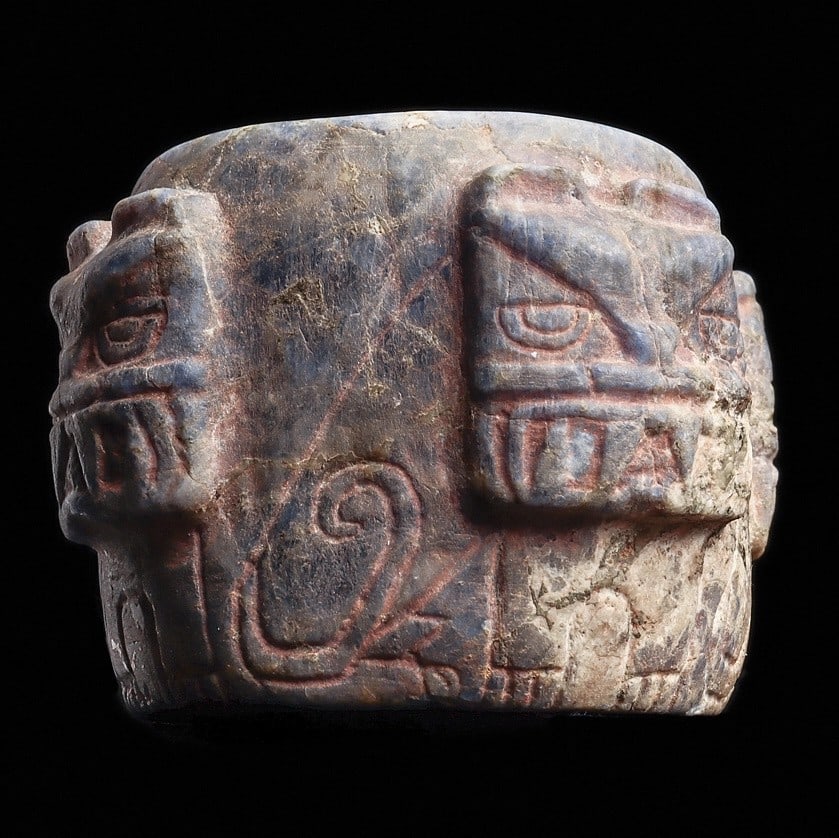 Chavin Lapis (Sodalite) Decorated Vessel: Chavin, ca. 400 BCE. Carved mottled blue sodalite-lapis vessel, having four jaguar heads carved in high relief, each having a wide fanged mouth and large eyes, their bodies are incised under each head