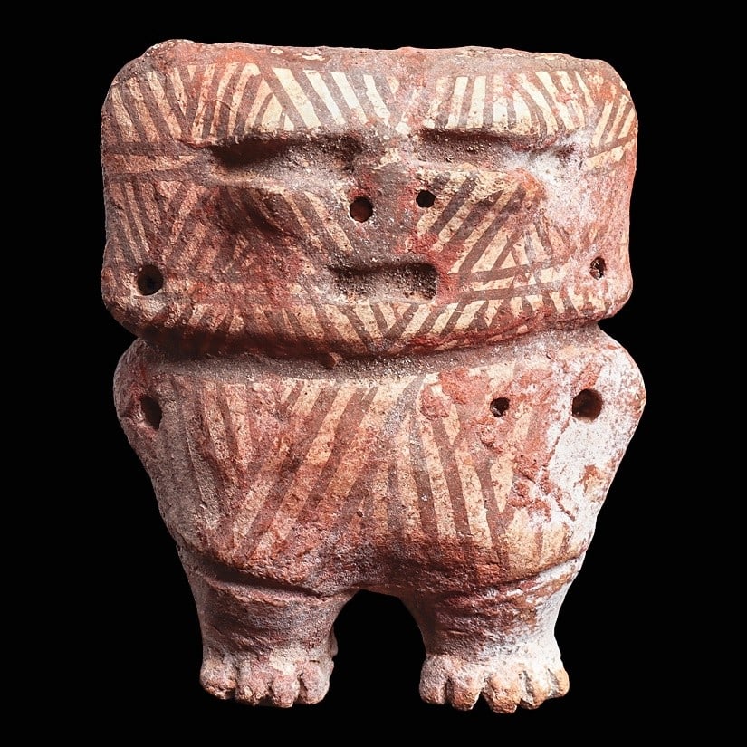 Timoto-Cuica Miniature Rattle Figure: Venezuela, ca. 700 - 1200 CE. Small semiabstract rattle type figure having a rectangular head and perforated lug type arms. Decorated with painted red-brown diagonal stripes on a cream ground. A nice 