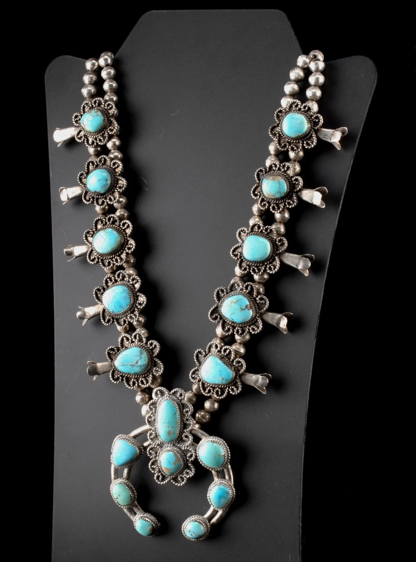 Dine Silver & Turquoise Squash Blossom Necklace: Native American, Southwestern United States, Navajo., ca. 1900 - 1966 CE. A stunning sterling silver and turquoise squash blossom necklace set with ovoid turquoise stones. The necklace is comprised of