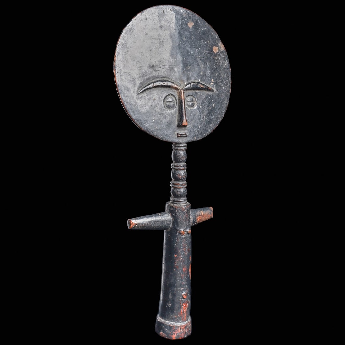 Akua’ba Fertility Figure: Ghana, . Elegantly carved fertility doll with a disc-shaped head, the reverse deeply engraved with an abstract motif. The figure features an elongated neck with detail and a columnar body with arms