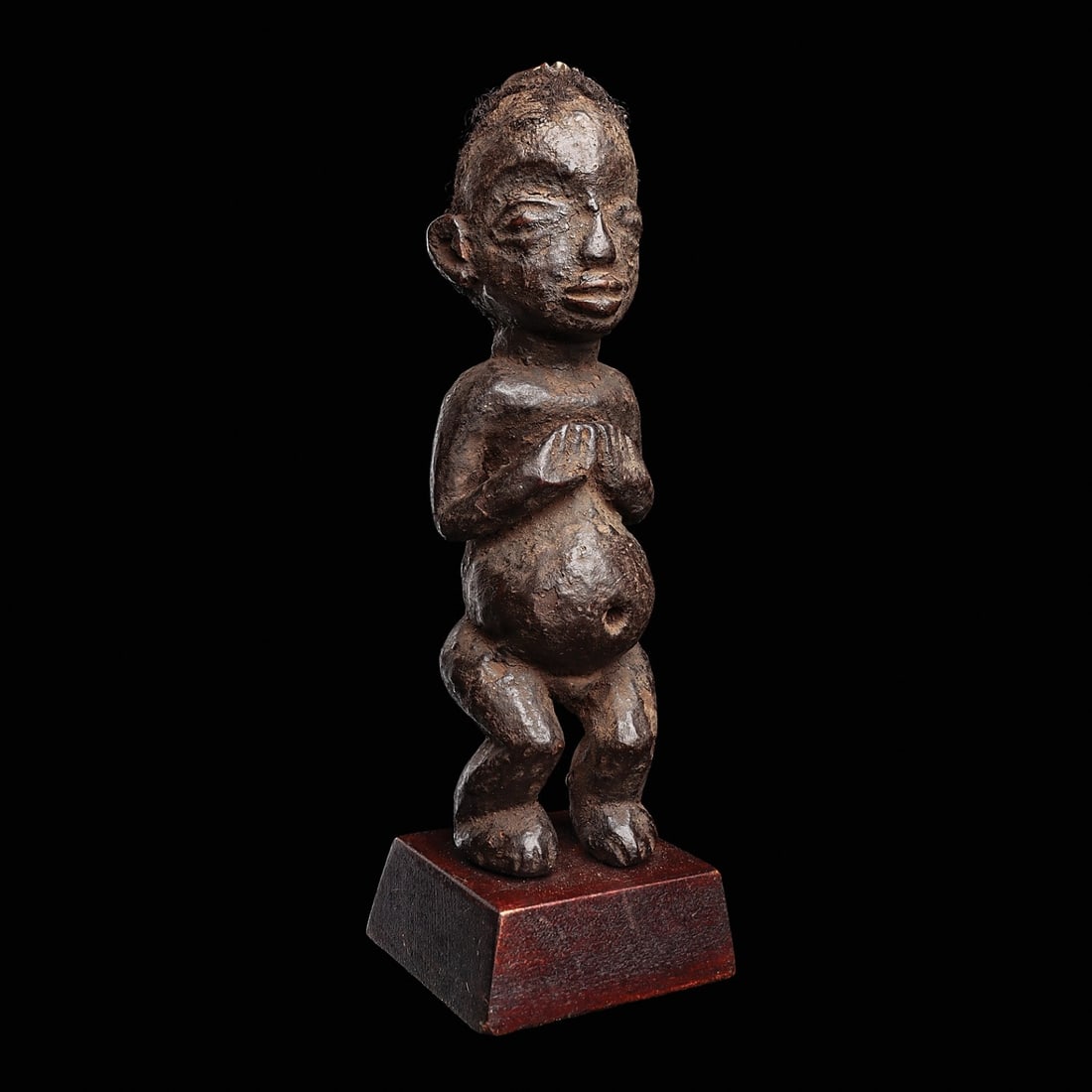 Mupo Fetish Figure: Bamileke, Cameroon, . Divination female figure carved with rounded abdomen with hollowed navel, arms bent to place hands above. The wide face with rimmed eyes, with human hair applied around head,