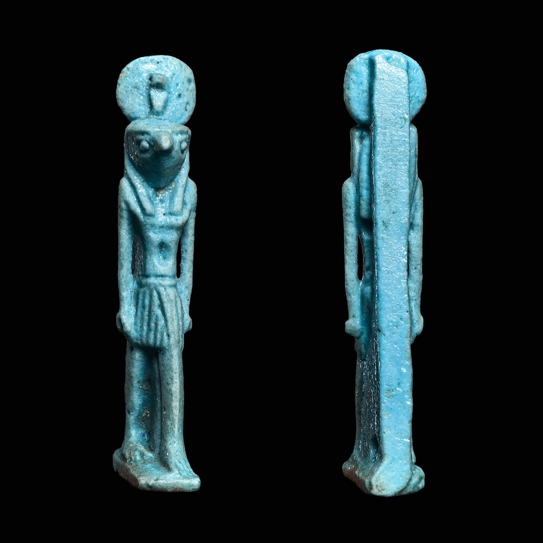 Fine Egyptian Light Blue Faience Horus Amulet: Egypt, tIP, ca. 1200 BCE. Fine blue glazed faience pottery amulet depicting the god Horus, as the hawk headed god, striding on an integral rectangular plinth base. Wearing the royal wig, a short pleat