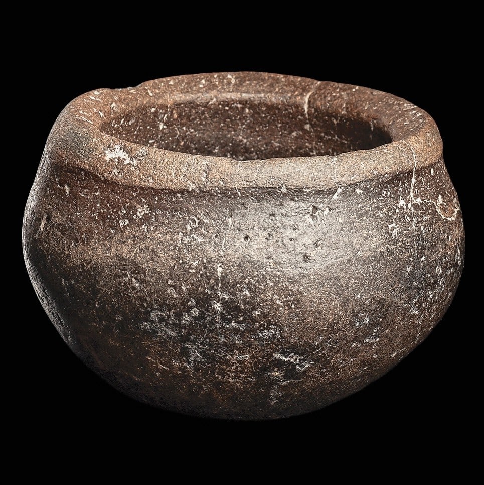 Egyptian Basalt Bowl: Egypt, late period, ca. 700 - 30 BCE. Thick walled black basalt stone bowl having a carved slightly raised rim and tapered bulbous lower body.3”H x 4.375”D (7.6 x 11.1cm). Provenance: Coll