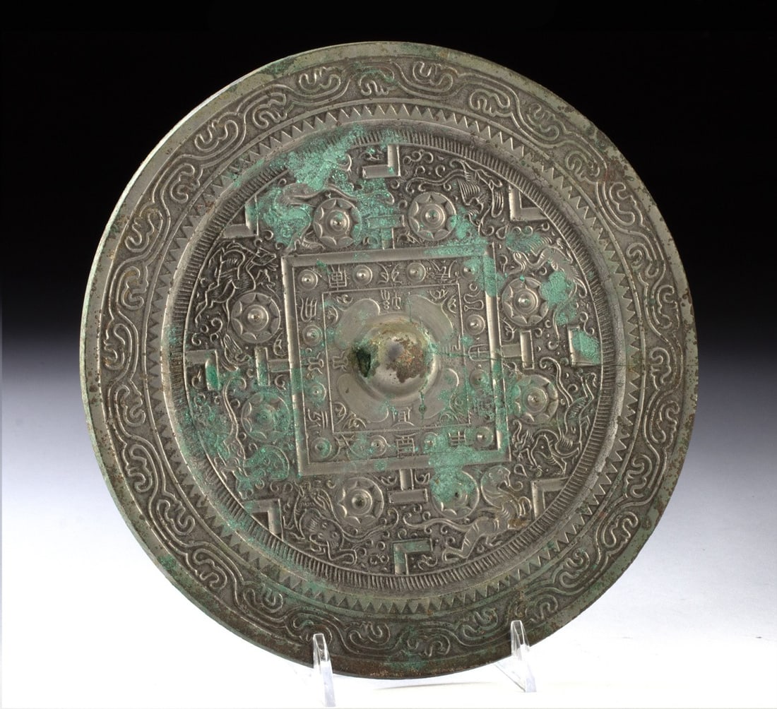 Han Dynasty Bronze Mirror - Phoenix & Sun Motifs, Pierced Handle: East Asia, China, Han Dynasty., ca. 206 BCE - 220 CE. An incredible bronze mirror with cast motifs on its decorated back and a raised, nub-like handle on the back. The handle is pierced through, allow