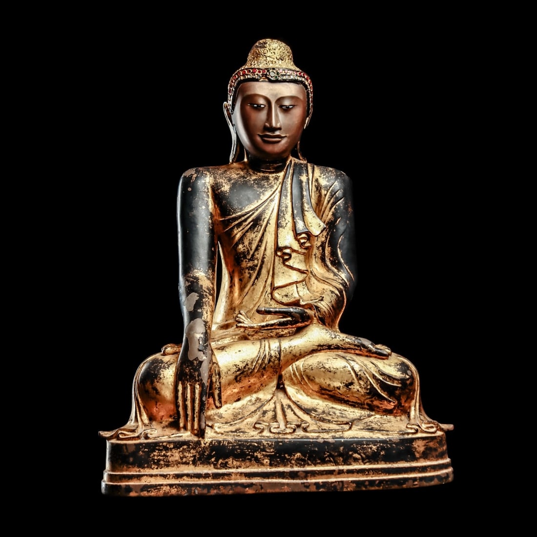 Burmese Large Bronze Buddha: Thailand, ca. 17th century. Large cast bronze Buddha on an integral tiered base. Buddha depicted looking slightly downwards, with a serene facial expression and having inset mother of pearl eyes, tigh