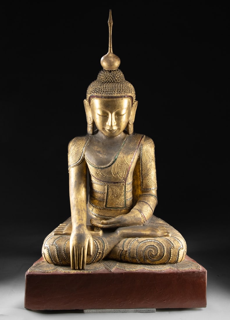 Larger-Than-Life 18th C. Burmese Gilt Buddha: Southeast Asia, Burma (Myanmar)., ca. 1766 - 1899 CE. An astounding gilt lacquer Buddha of monumental scale adorned with intricate relief designs as well as inlays of red, green, and white glass and l