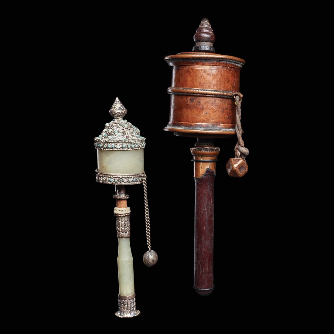 Tibetan Prayer Wheels (2): Tibet, ca. 18th - 19th century. Two different prayer wheels, including one having a copper wheel with banded rings having finely incised serrated edges, carved wood flame finial and hardwood handle. T