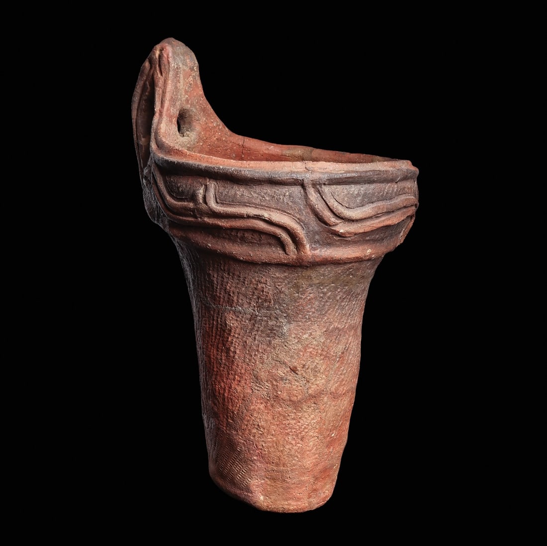 Jomon Ceramic Vessel: Japan, ca. 14,500 - 300 BCE. Red-brown pottery vessel having a texture decorated tapered cylindrical body with a wide collar rim lip decorated in relief with four large wave-like elements and a tall p