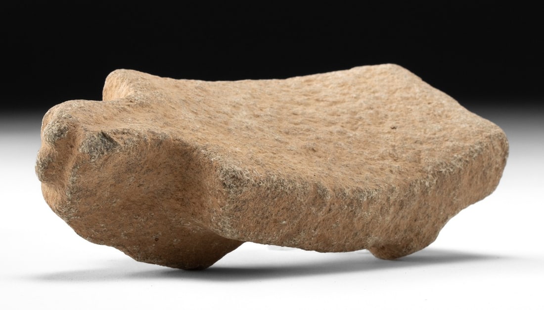 Colima Stone Metate - Miniature Grinding Stone: Pre-Columbian, West Coast Mexico, Colima, ca. 300 BCE to 300 CE. A petite stone metate or grinding stone carved from a coarse tan stone and raised on four short legs with small face emerging from fron