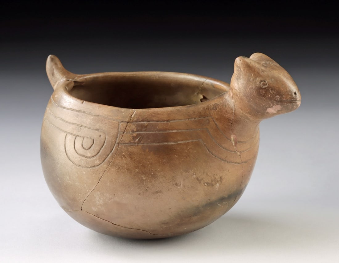 Caddo Pottery Etched Animal Effigy Pot: Native American, Mississippian, Caddo culture, ca. 900 to 1500 CE. A finely burnished pottery effigy bowl, its rounded form animated by a stylized animal head and tail with incised curvilinear motifs 