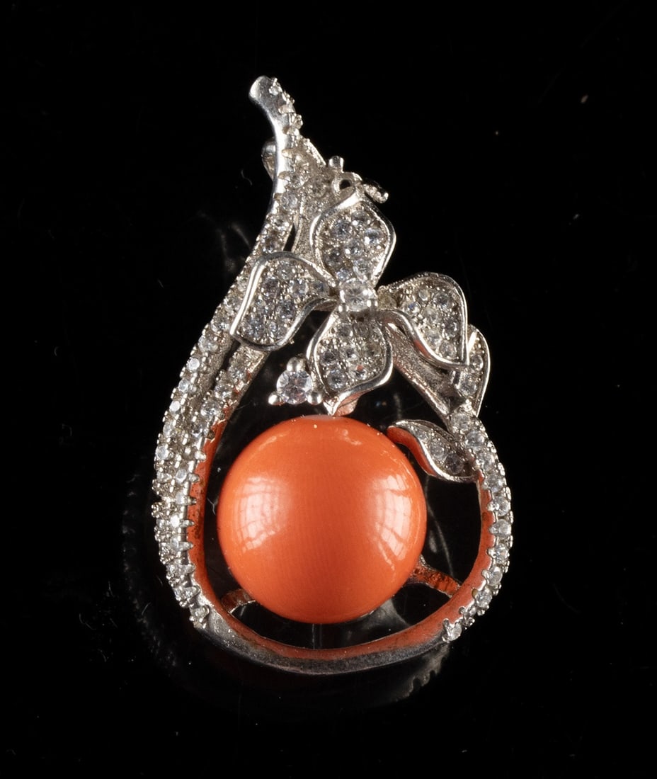 Sterling Silver & Coral Bead Pendant: United States, ca. mid-20th to 21st century CE. A sterling silver costume jewelry pendant featuring a vivid coral-colored sphere cradled within an openwork teardrop frame formed as a flowing stem with