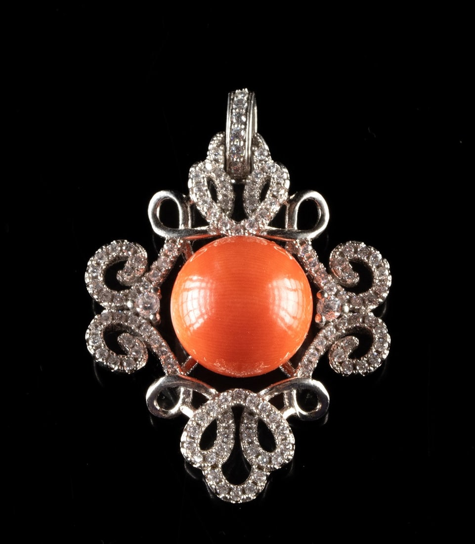 Silver Scrollwork Pendant with Coral Sphere: United States, ca. mid-20th to 21st century CE. A sterling silver costume jewelry pendant featuring a vivid coral-colored sphere set within an openwork frame. The piece is stamped "925" on the bail, a