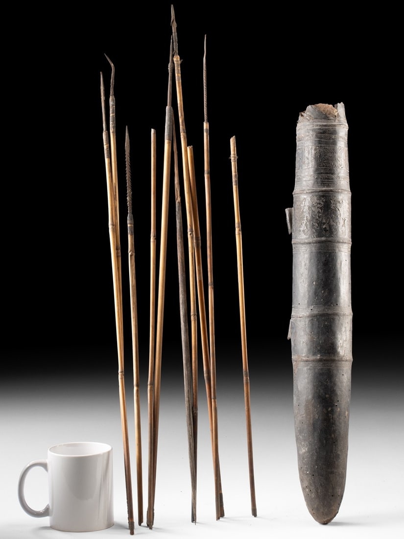 Papua New Guinea Bark & Hide Quiver w/ 12 Wood Arrows: Oceania, Papua New Guinea, ca. 20th century CE. A striking hunting set, this Papua New Guinea quiver retains its original complement of twelve arrows, offering a complete and tangible glimpse into the
