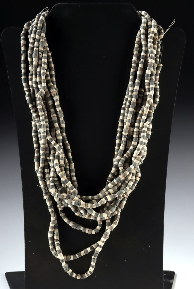 Ten Strands of Ancient Mesopotamian Shell & Stone Beads: Near East, Mesopotamia, Sumer, ca. 3000 to 1000 BCE. A group of ten strands of ancient steatite and shell beads in tones of white, charcoal, and soft gray. The beads are small and evenly shaped, are p