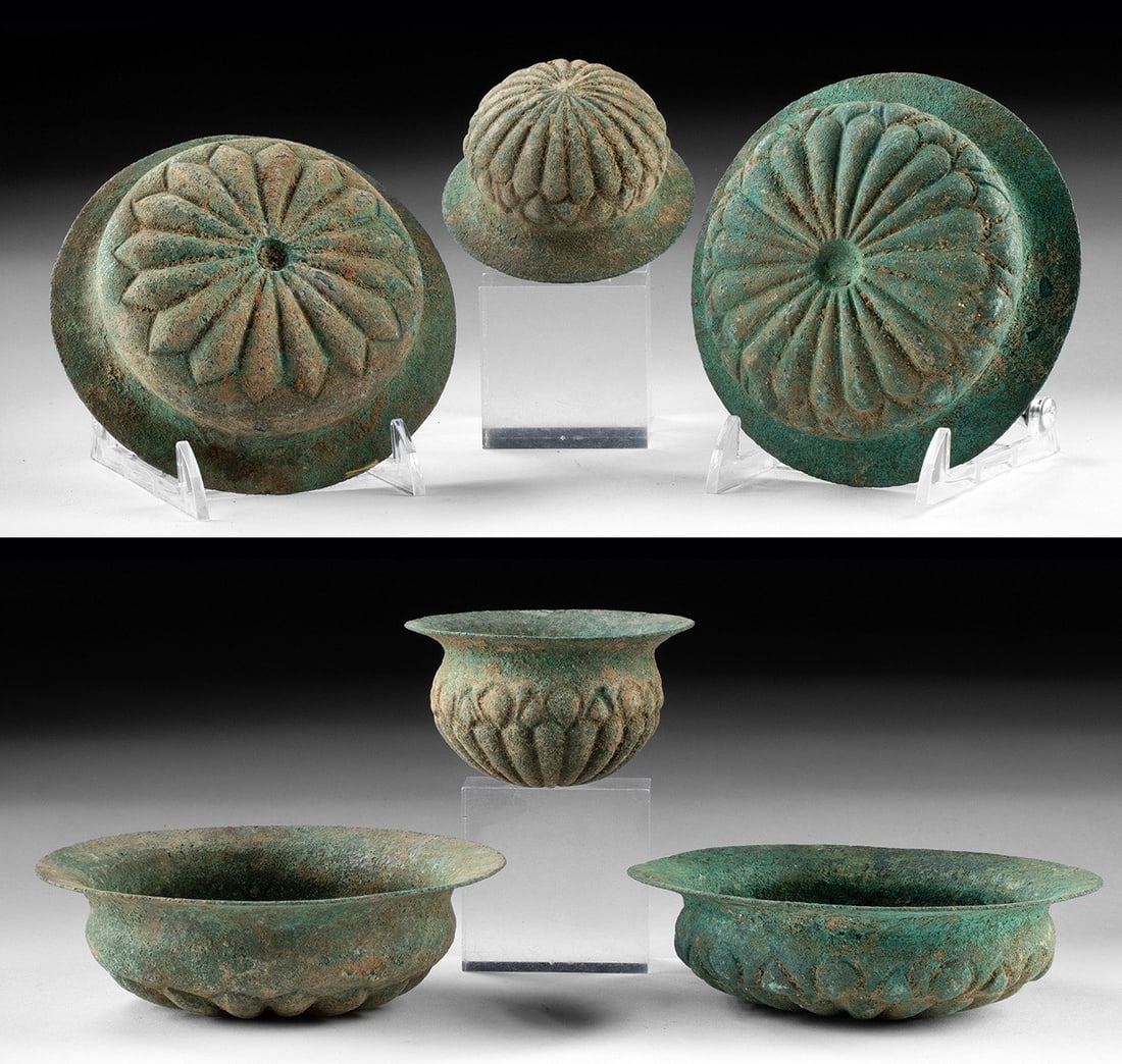 Persian Achaemenid Copper Lotus Petal Bowls (3): Ancient Near East, Persia, Achaemenid Empire, ca. 550 to 330 BCE. A group of three cast copper bowls of Achaemenid manufacture, each decorated with a radiating lotus petal motif in relief encircling t