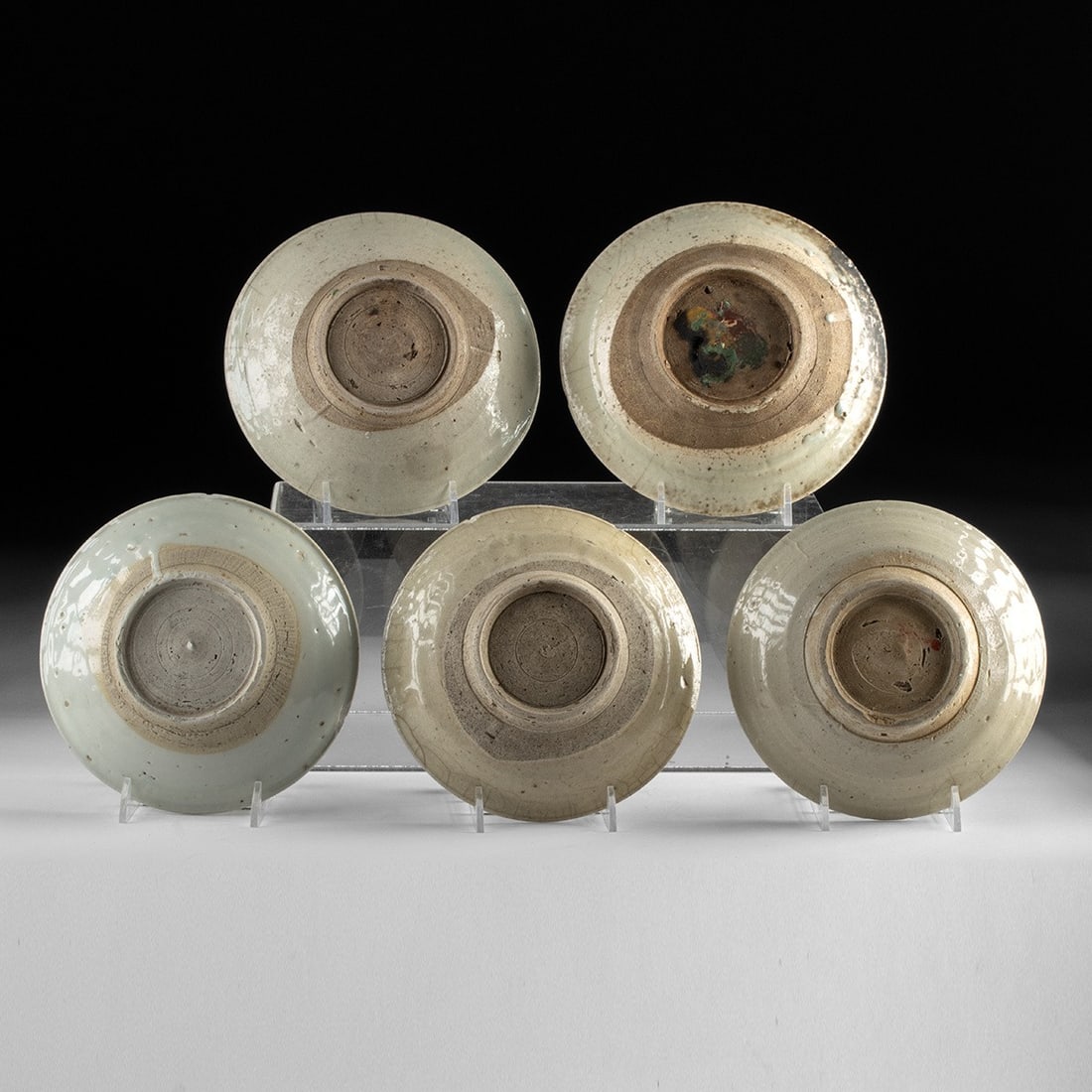 Chinese Qing Dynasty Shipwreck Dishes, Set of 5: East Asia, China, Qing Dynasty, ca. 1700–1850 CE. A group of five stoneware dishes recovered from a maritime shipwreck, each covered in a pale gray-green glaze decorated with stenciled cobalt ch