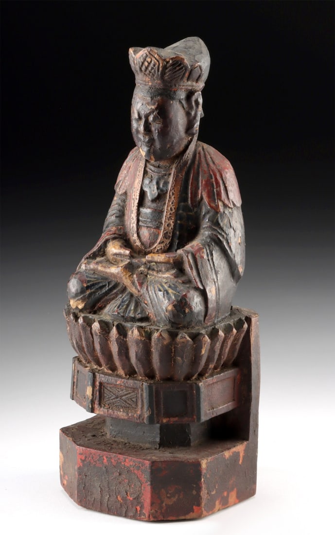 Chinese Qing Dynasty Wooden Shrine Figure on Lotus Base: East Asia, China, Qing Dynasty, ca. 19th century CE. A devotional wooden figure depicting a crowned deity such as Guanyin or ancestor seated serenely upon a lotus pedestal base. The figure's hands res