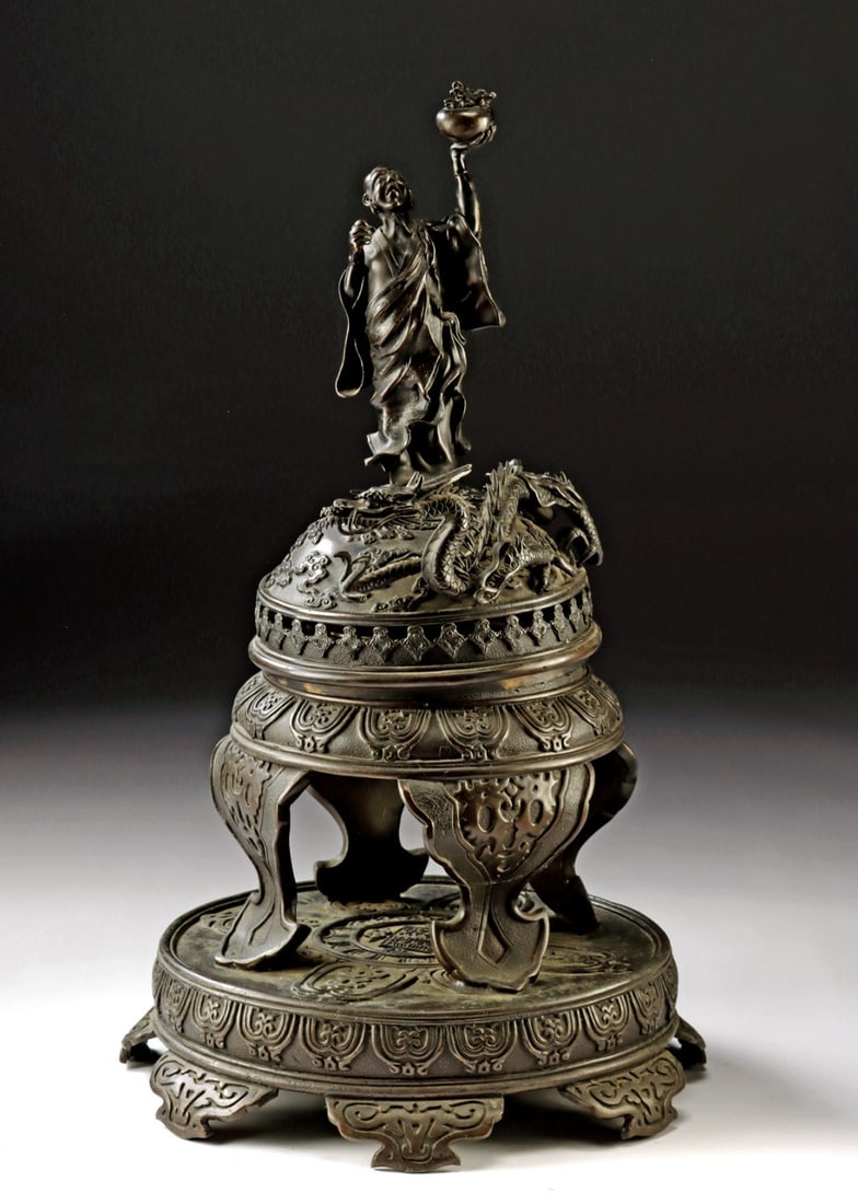 19th C. Japanese Meiji Bronze Censer, Dragon & Immortal: East Asia, Japan, late Edo to Meiji era, ca. 19th century CE. An elaborate leaded bronze censer and sculptural centerpiece formed with a domed, pierced lid designed to release incense smoke, the surfa