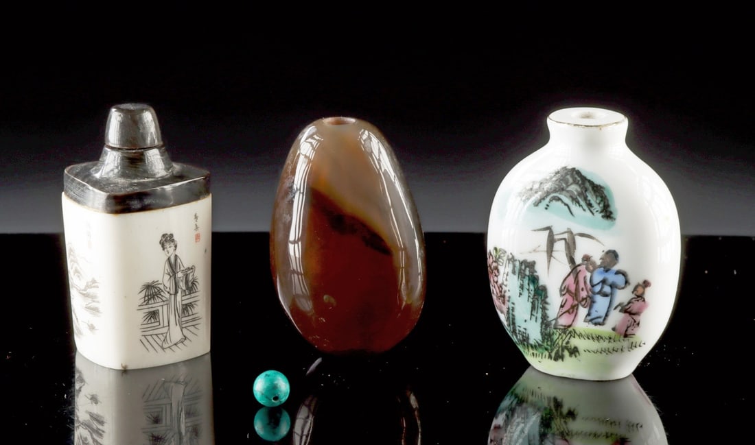 Three Chinese Agate, Bone & Porcelain Snuff Jars: East Asia, China, Qing Dynasty, ca. 19th to mid-20th century CE. A collection of three snuff bottles in varied materials. One is carved bone fitted with a dark cowhorn lid, its sides engraved with a s